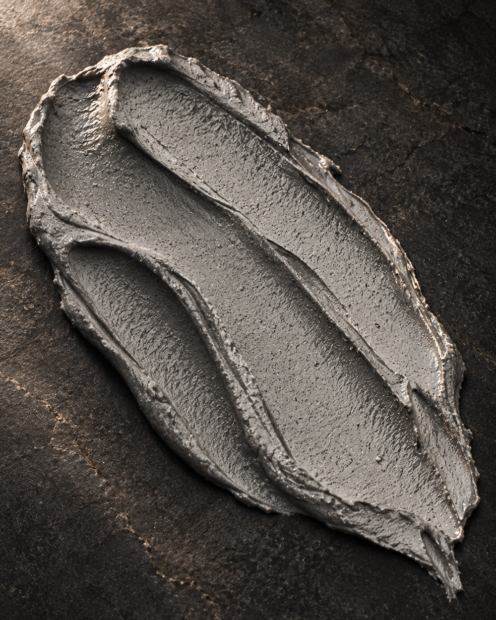 Gray clay-mask smear on dark stone.